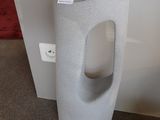des toilettes avec un distributeur de papier posé au sol à côté d'un distributeur de papier toilette
