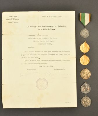 un vieux document, une médaille et d'autres objets posés sur une table
