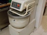 un grand robot blanc posé dans une cuisine, à côté d'une cuisinière