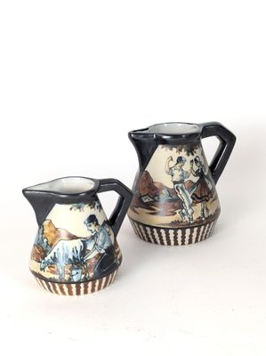 pair of japanese style pottery pitchers with painted figures