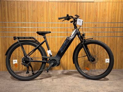 an image of a black electric bike parked in front of a wooden wall