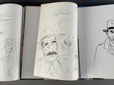 three open books with drawings of men in hats and hats on them