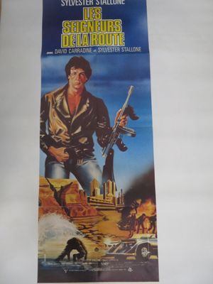 une vieille affiche de cinéma représentant un homme tenant un pistolet devant un décor désertique