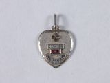 a close up of a silver heart shaped charm on a white surface
