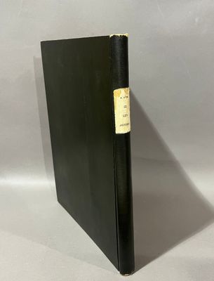 a black book sitting on top of a table next to a white wall