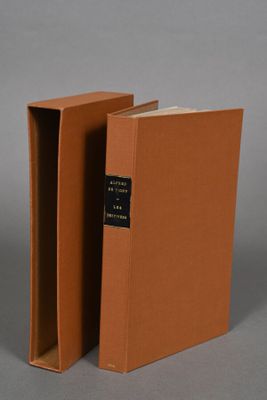 two brown books with black bindings sitting on top of each other