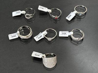 several different types of rings with price tags on them on a table