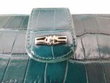 a green purse with a metal clasp on it