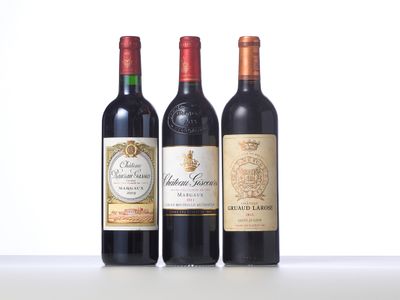 three bottles of red wine are lined up on a table