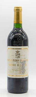 une vieille bouteille de vin posée sur une table blanche