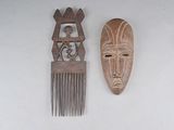 two wooden combs and a wooden mask on a table