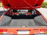 a red car with its trunk open in a parking lot
