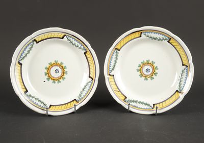 deux assiettes ornées de motifs jaunes et verts sur un fond noir