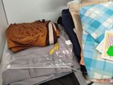 a pile of clothes and other items on a shelf