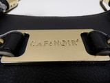 the handle of a black purse with a name tag on it