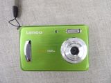 a green camera sitting on a table with a cord