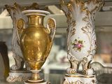 two vases sitting on a glass shelf in a glass case