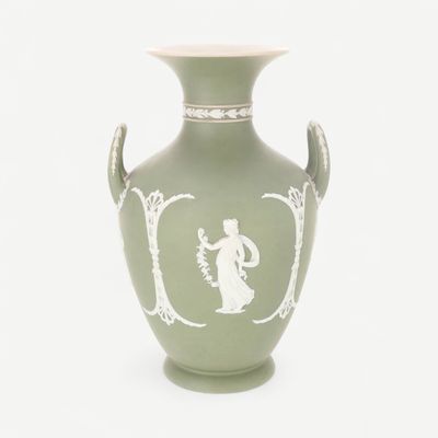 a green vase with a picture of a woman on it