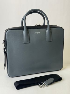 a grey briefcase with a black strap and a black strap