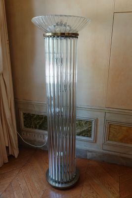 un grand vase en verre posé sur un parquet en bois massif
