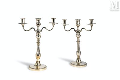 a pair of silver plated candlesticks on a white background