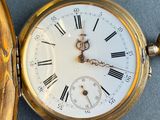 a gold pocket watch with roman numerals on it