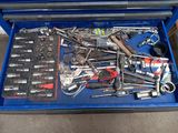 une boîte à outils bleue remplie d'outils divers, posée par terre