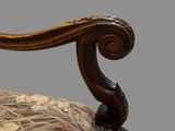 a close up of a chair with a floral upholstered back