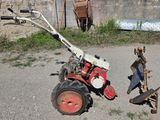 un petit tracteur équipé d'une charrue
