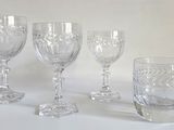 quatre verres à vin posés sur une table, sur fond blanc