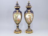 une paire de vases bleus et dorés ornés d'une peinture