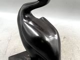 statue d'un pélican posé sur un socle noir, sur fond blanc