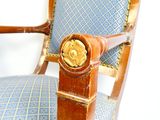 une chaise en bois dont l'assise est recouverte d'un tissu bleu et or