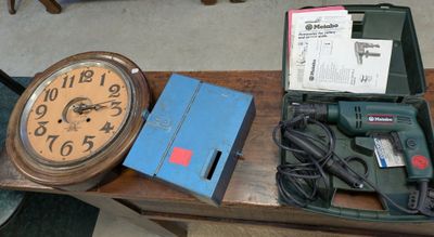 a table with a clock, drill, and other items on it
