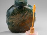 a green vase with a wooden spoon next to it