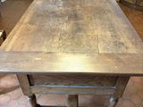 une table en bois avec un plateau en bois posée sur un sol carrelé