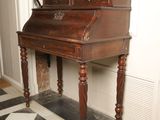 a small wooden desk with a mirror on top of it