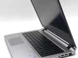 a silver laptop with a black keyboard on a white surface