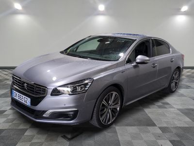 une voiture argentée est garée dans une pièce au sol en damier
