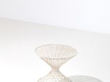 une image représentant une table blanche sur laquelle est posé un motif en fil de fer
