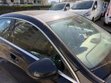 a black car parked in a parking lot with other cars in the background
