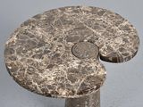 a marble table with a circular top on a gray surface