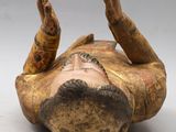 an old wooden statue of a man laying on his back