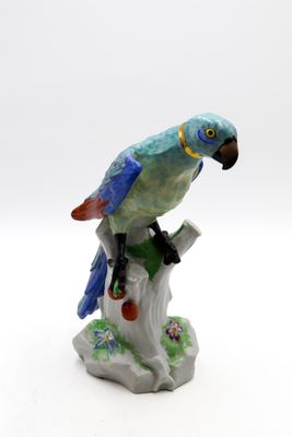 une figurine représentant un perroquet perché sur une branche d'arbre