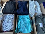 several pairs of pants are in a cardboard box on the floor