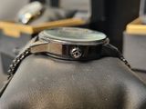 a watch that is sitting on top of a leather bag