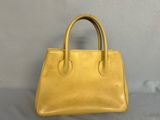 a yellow leather handbag sitting on top of a table