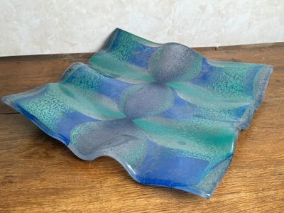 a blue and green glass plate on a wooden table