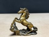 statue of a horse standing on its hind legs on a rock
