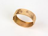 gros plan d'une bague en or sur une surface blanche
